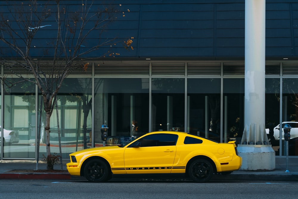 yellow coupe parked outside building