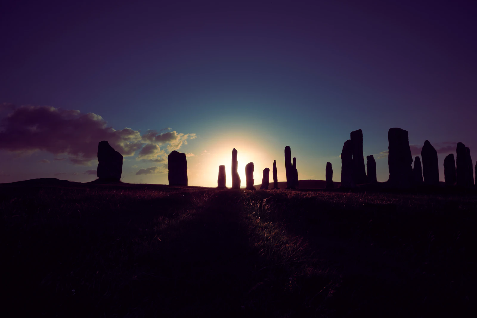 The tall standing stones of Calanais under a blue sky on the Isle of Lewis