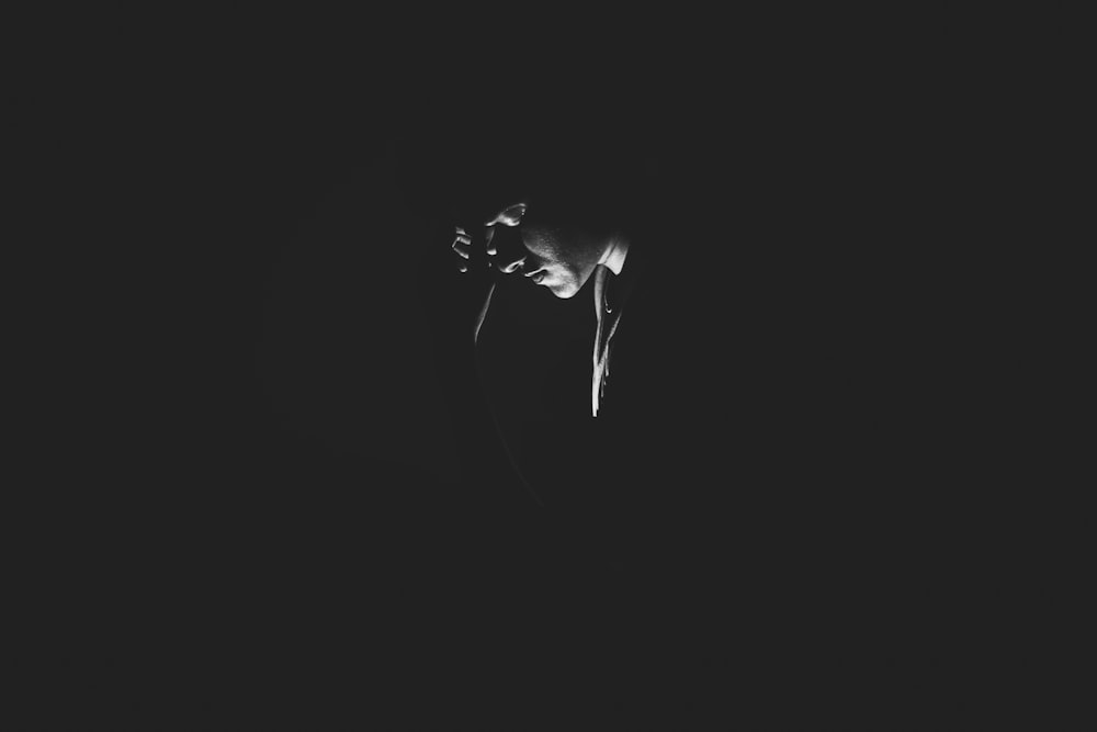 a black and white photo of a person in the dark