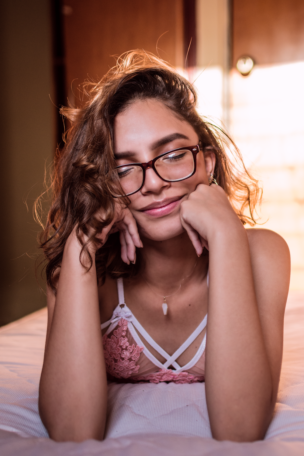 Eine junge Frau mit Brille, die auf einem Bett liegt