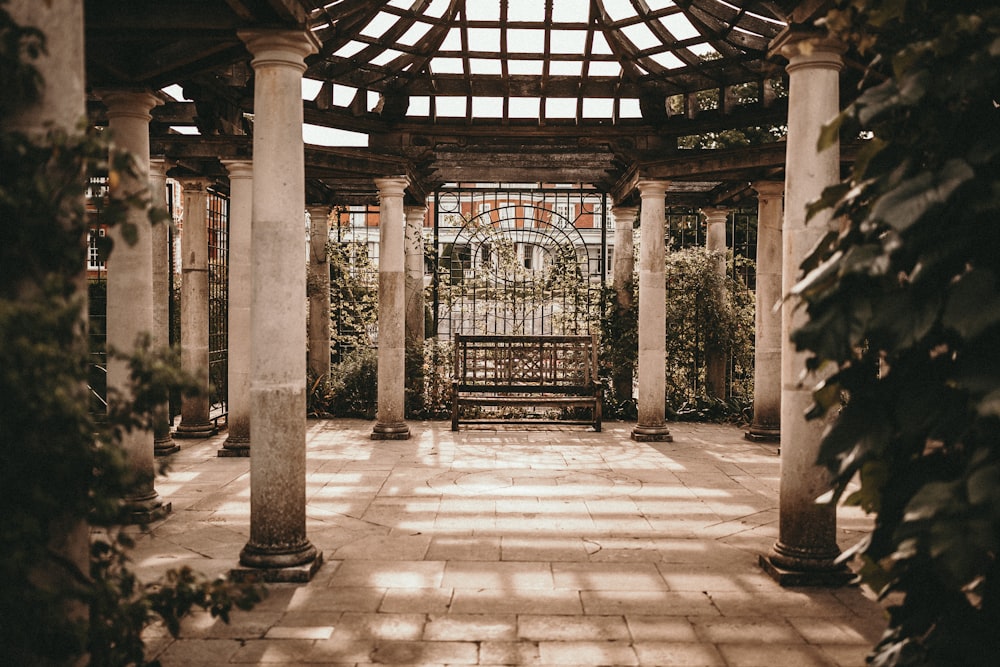 empty wooden bench between stone pillars