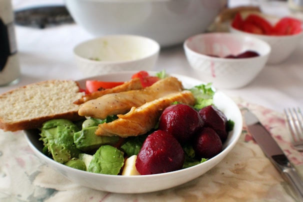 A vibrant plate of keto-friendly avocado and golden roast chicken with fresh greens.