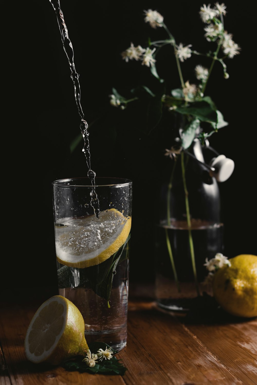 clear drinking glass beside flower vase