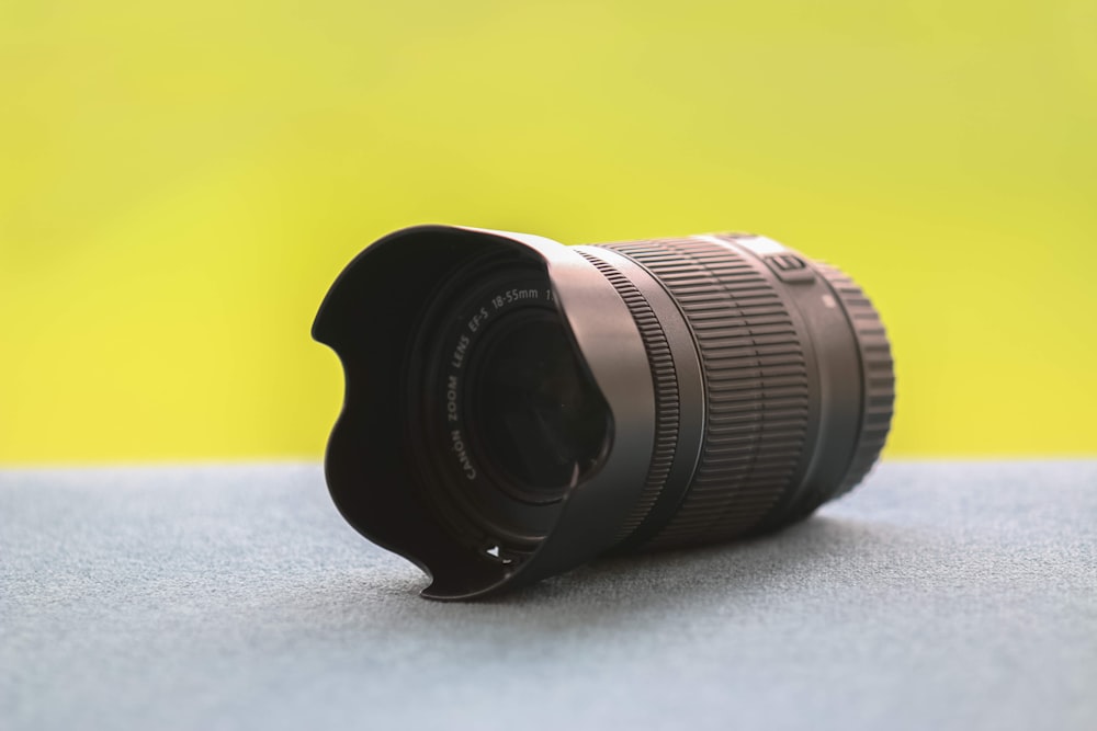 black DSLR camera lens on gray surface