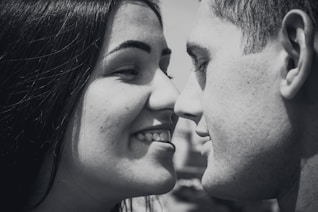 woman and man facing each other while smiling