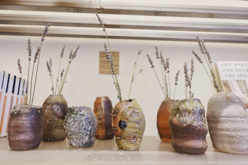 A collection of antique vases displayed on a rustic shelf.
