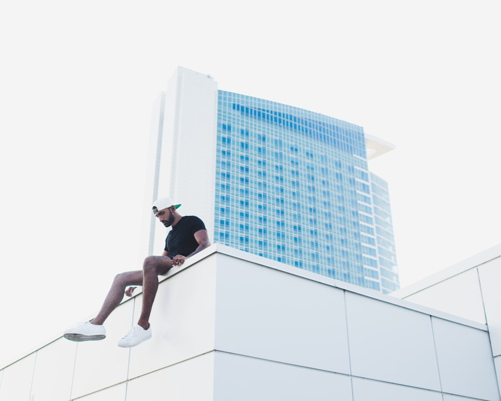 man sitting at the roof of the building
