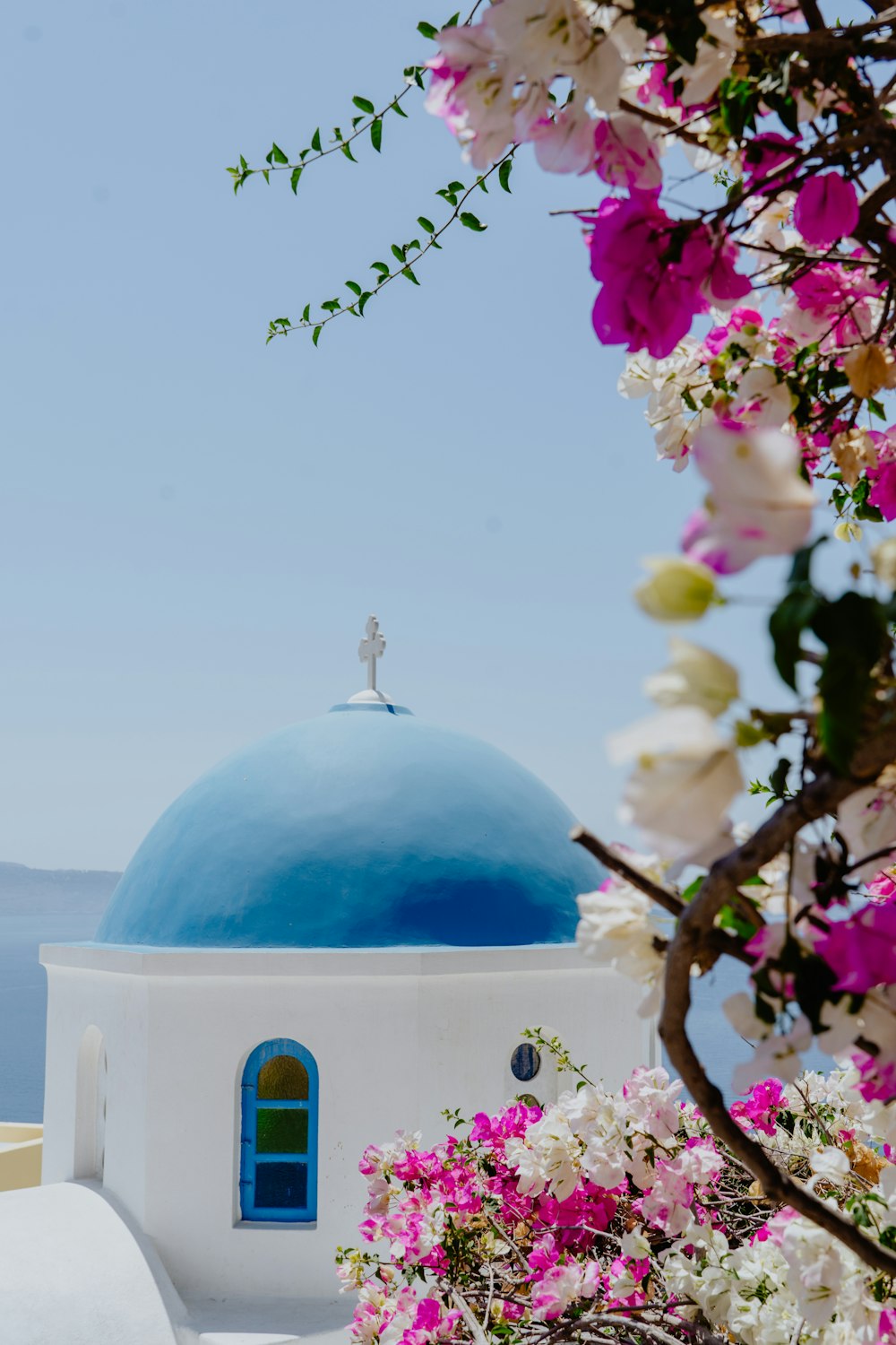 een blauw witte kapel met roze bloemen 