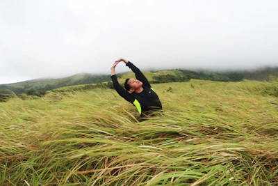 A person stretching outdoors during a morning walk in nature.