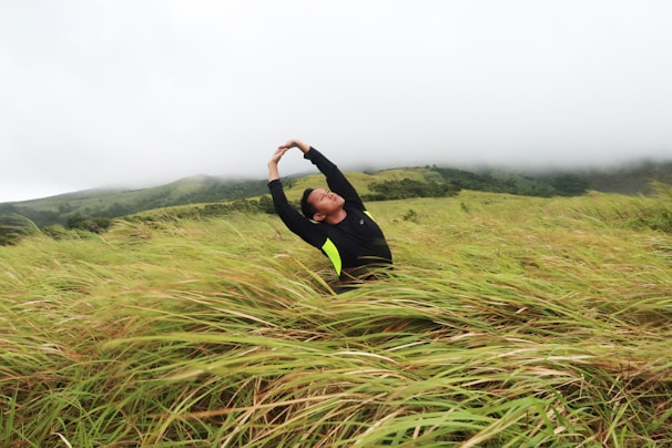A serene morning scene with a person stretching outdoors, bathed in soft green and blue light.