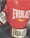 A pair of red boxing gloves with the brand name 'Everlast' prominently displayed on them. The gloves have white and black colored cuffs, and the surface appears glossy, suggesting they are made of leather.