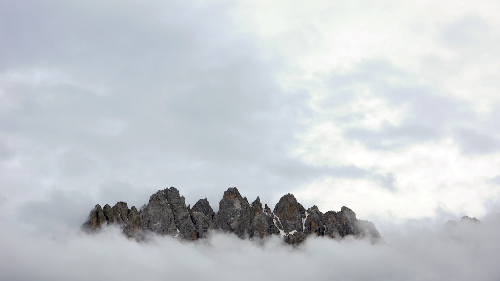 Photo en contre-plongée d’une montagne couverte de brouillard pendant la journée