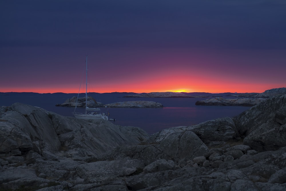 landscape photography of sailing yacht against golden sun