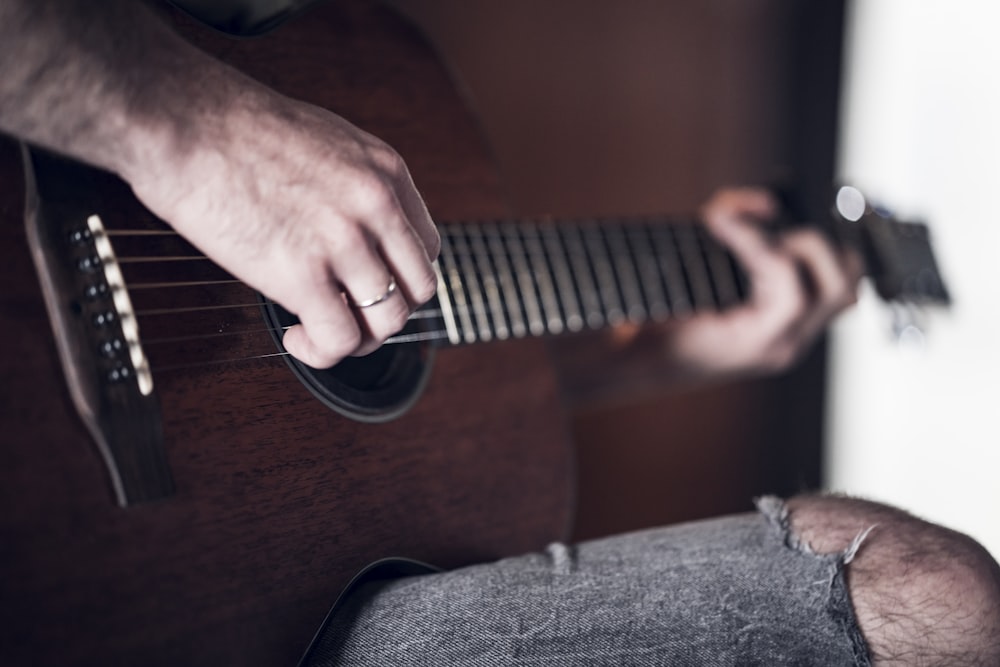 person playing acoustic guitar