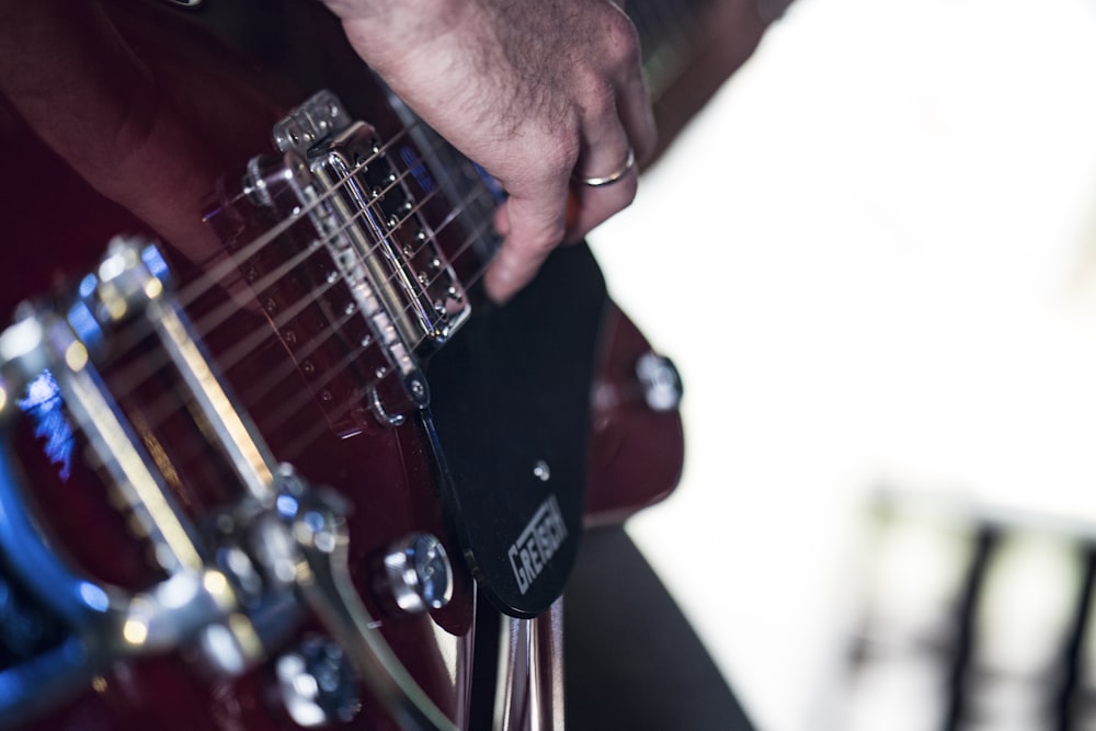 personne utilisant une guitare électrique