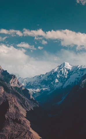 a mountain range with snow capped mountains in the background