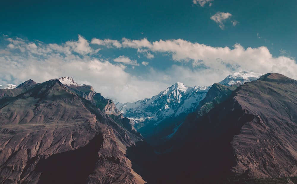 a mountain range with snow capped mountains in the background