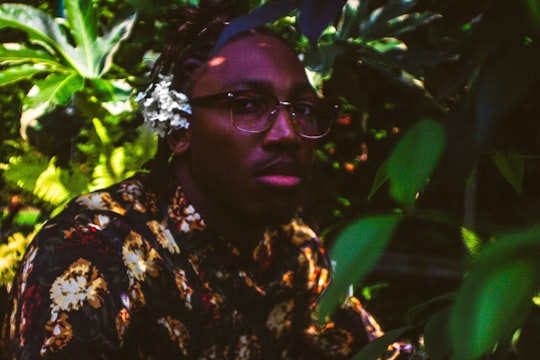 man wearing floral shirt taking photo under tree in Downtown Detroit United States