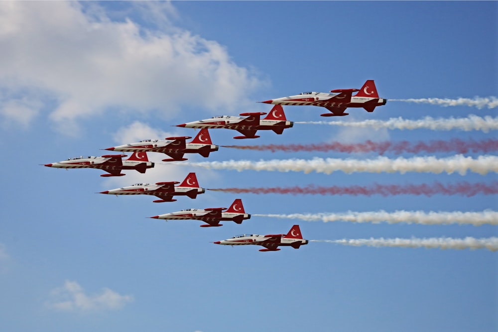 white-and-red fighter jets in the sky