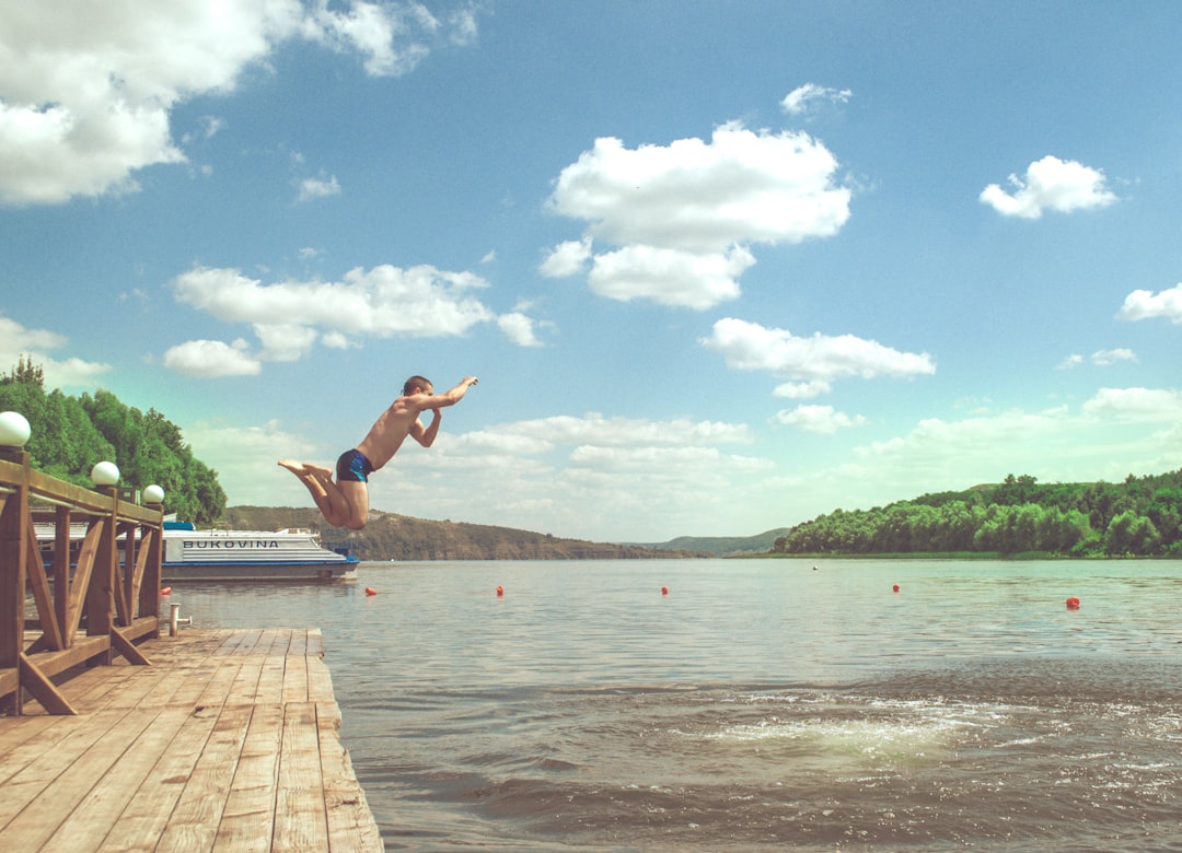 man diving on lake,