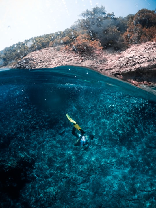 person diving on body of water in Hvar Croatia