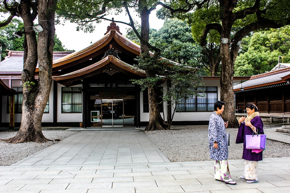 two women standing in front of house