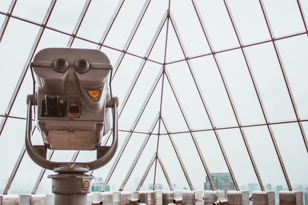 gray binocular viewer near glass curtain wall