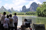 A diverse group of artists painting outdoors in a scenic landscape.