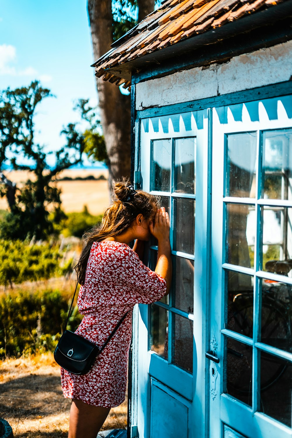 mulher espreitando na porta de vidro