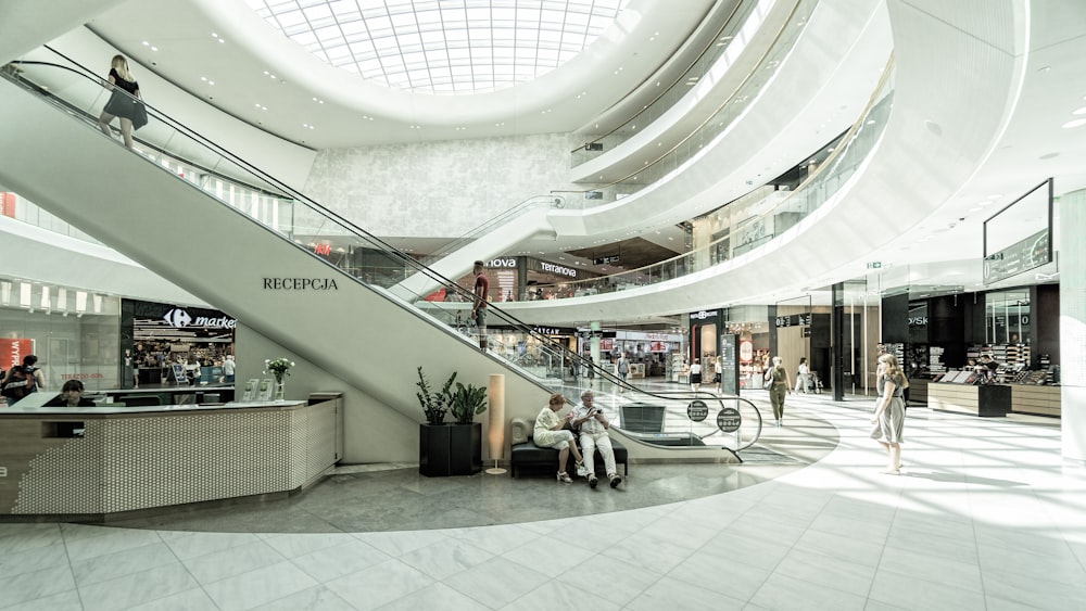 person sitting on chair beside escalator