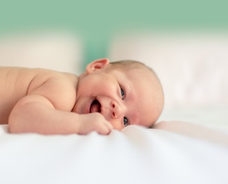 baby lying on fabric cloth