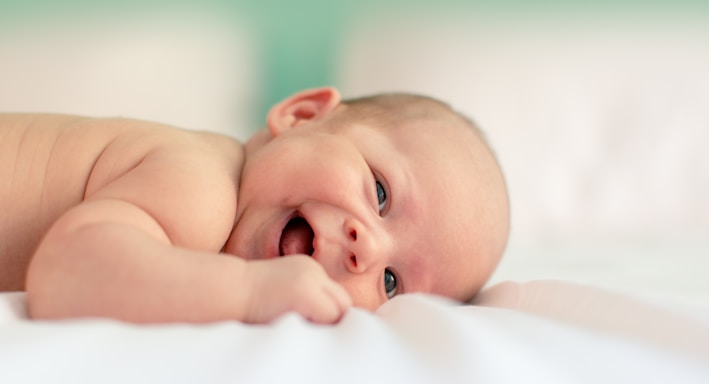 baby lying on fabric cloth