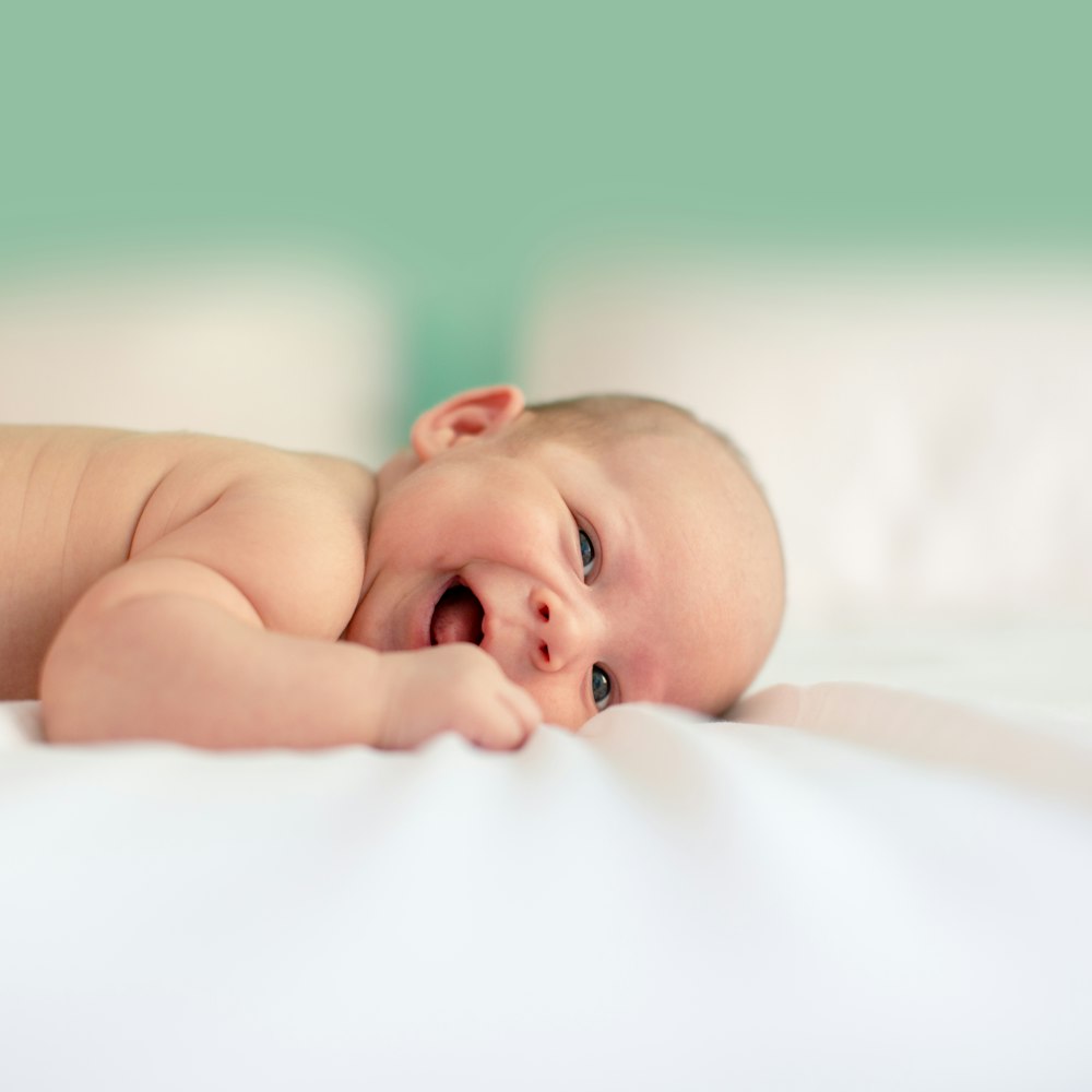 baby lying on fabric cloth