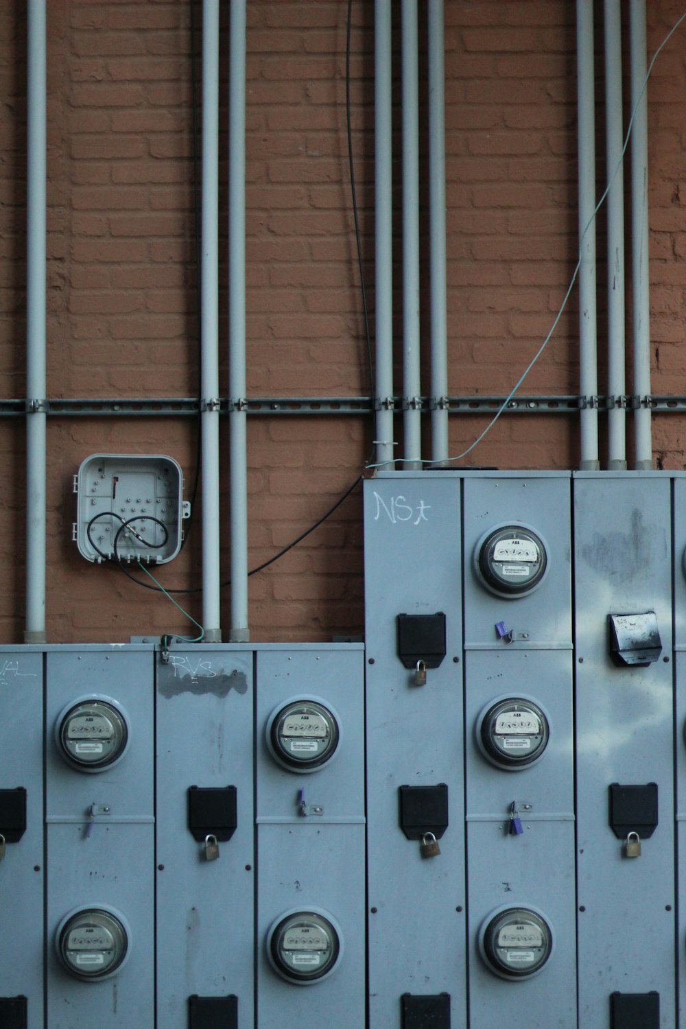 gray electric meter on brown wall brick