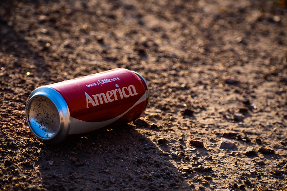 Boîte de conserve Coca-Cola America sur sol brun