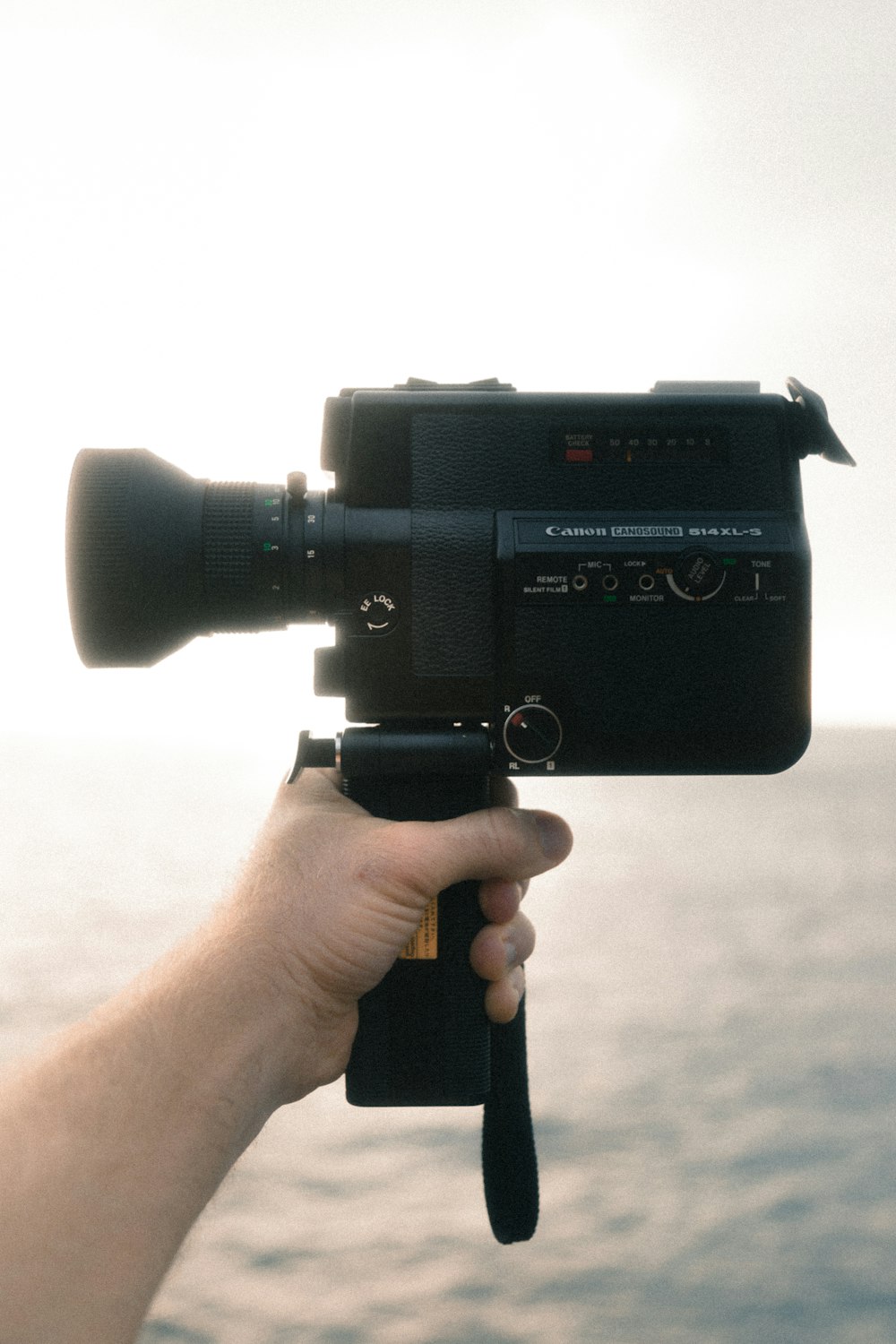 person holding black Canon video camera