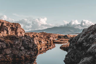 reflection of rock mountain on body of water