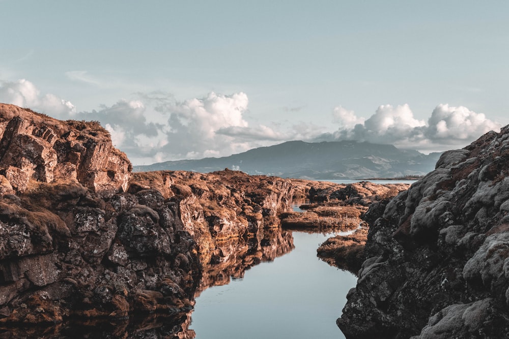 reflection of rock mountain on body of water