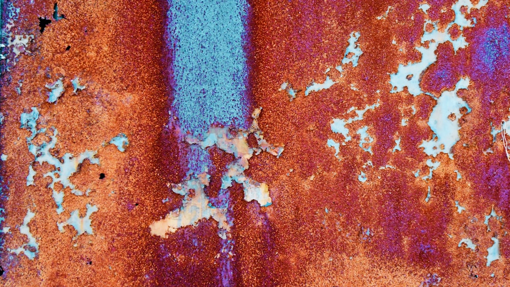 a rusted metal surface with blue paint on it