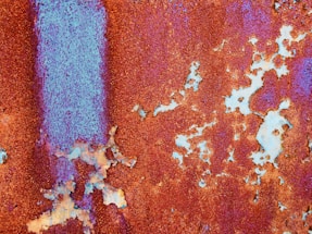 a rusted metal surface with blue paint on it
