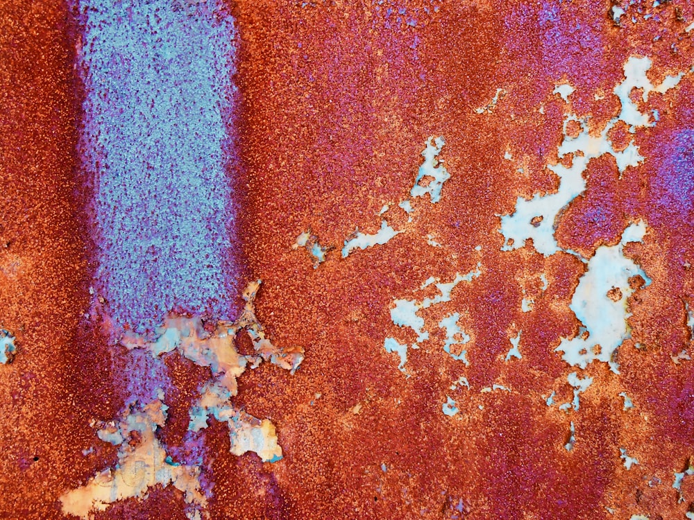 a rusted metal surface with blue paint on it