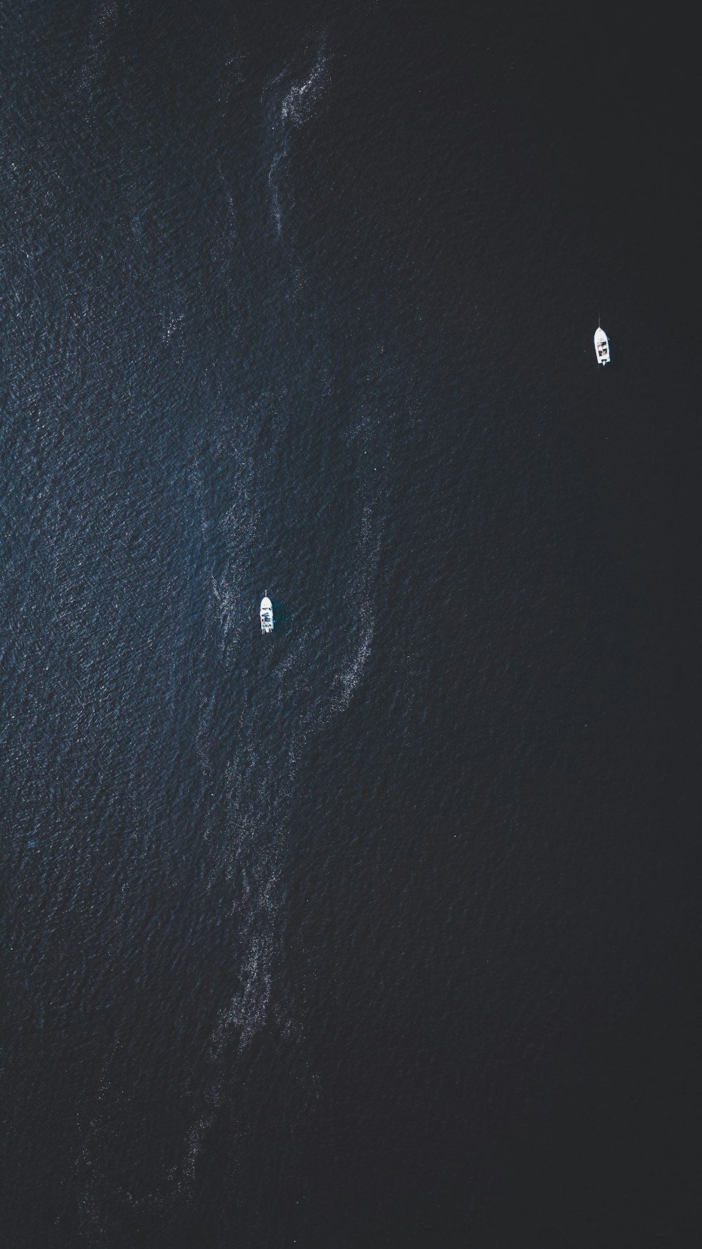 Draufsicht von zwei weißen Booten auf dem Wasser bei Tag