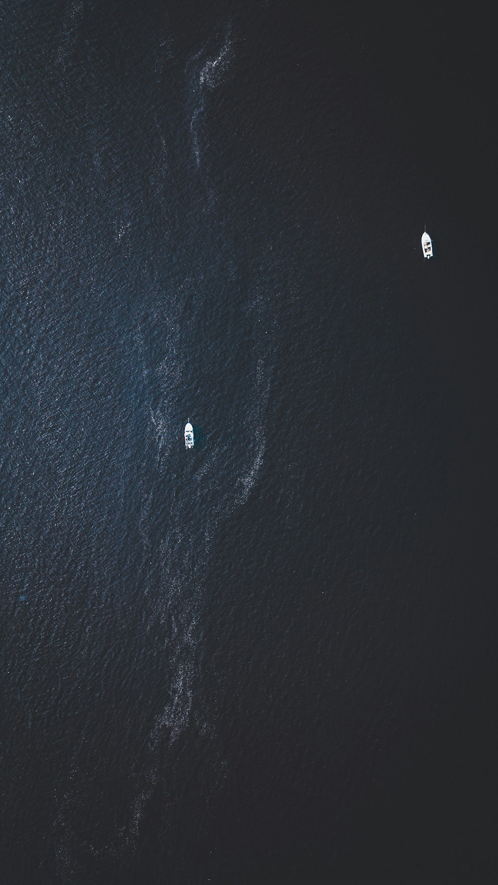 top view photography of two white boats on water at daytime