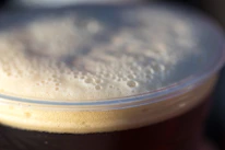 Close-up of a frothy Guinness beer poured perfectly in a branded glass.