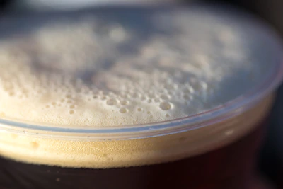 Close-up of a frothy Guinness beer poured perfectly in a branded glass.
