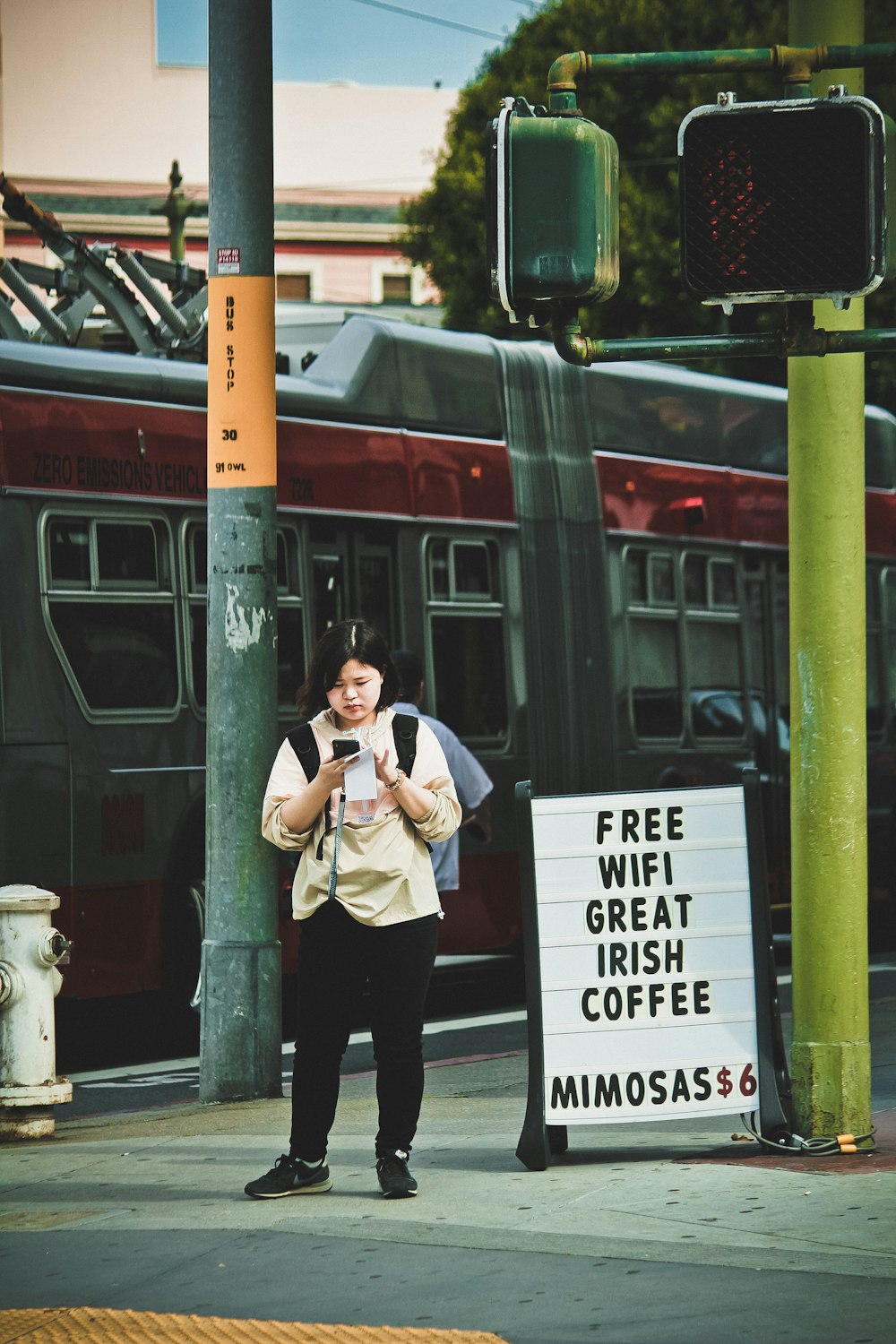 woman using phone near traffic light