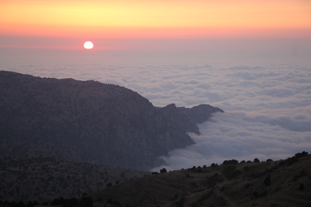 aerial photography of mountains and white clouds during golden hour