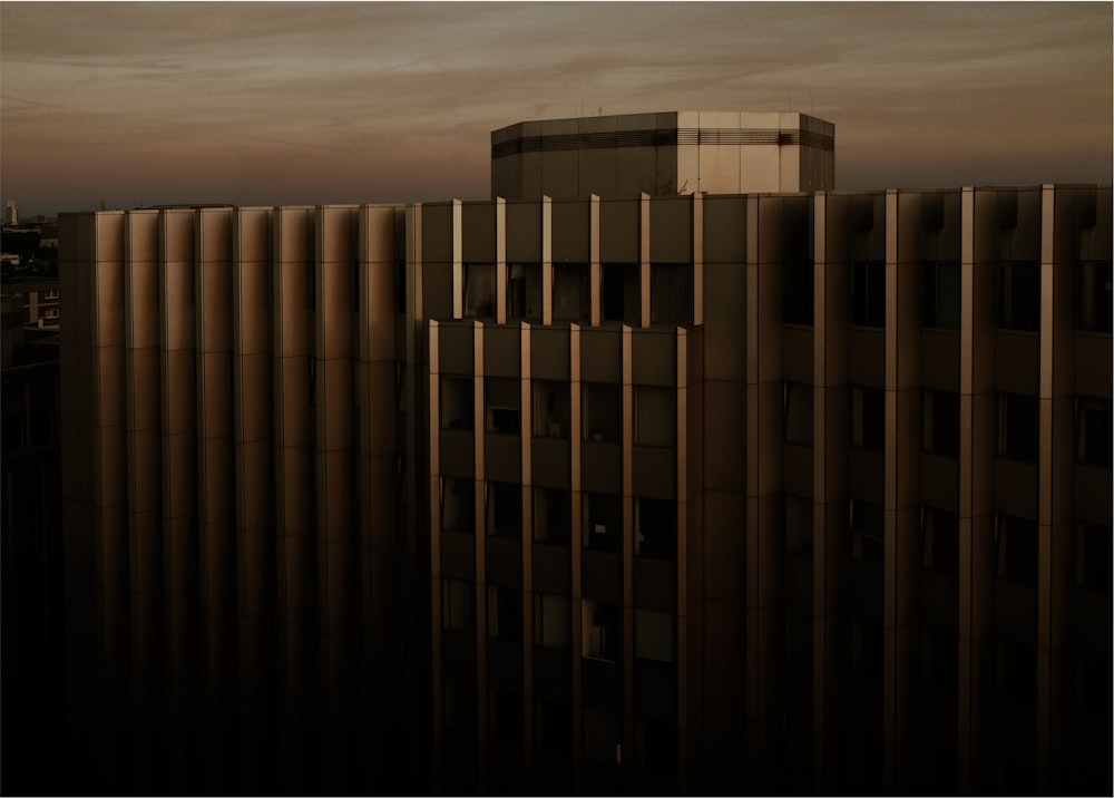 夕暮れ時の曇り空の下のベージュのコンクリートの建物