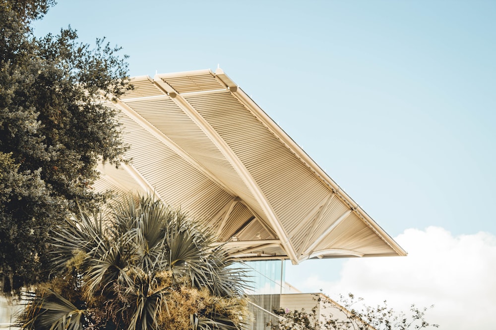 a large wooden structure sitting next to a lush green tree