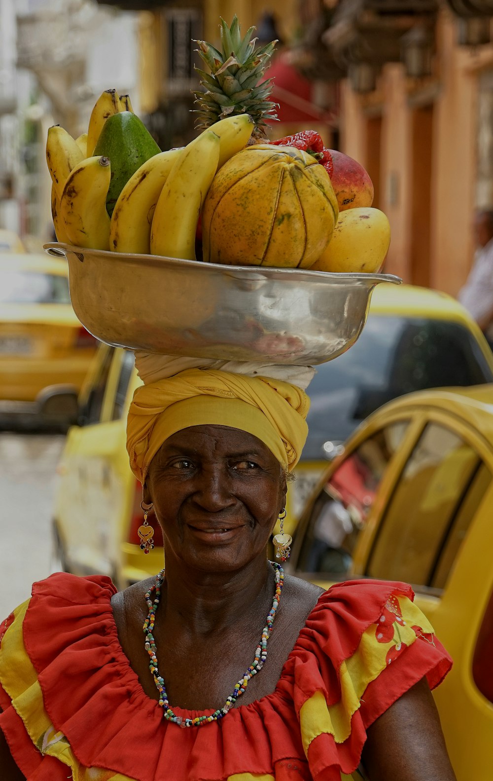 femme portant des fruits dans un bol